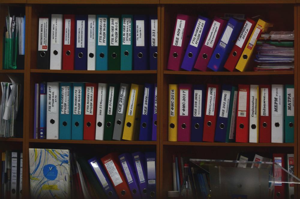 A shelf filled with labeled three-ring binders.