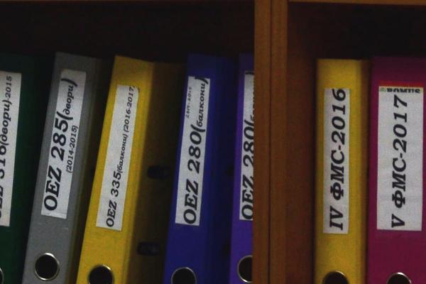 A shelf filled with labeled three-ring binders.