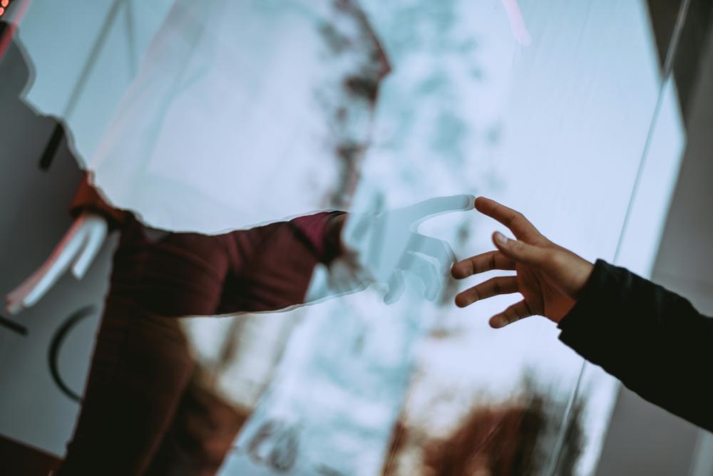 An image of a hand touching itself in its reflection on a mirror.